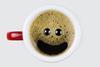 A photo of a cup of coffee with a smiley face appearing in the bubbles