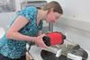 A photo of Katherine Curran working as a conservator at a museum