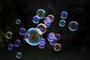 Bubbles of different sizes floating against a black background