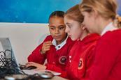 Photo of primary school children working on a laptop