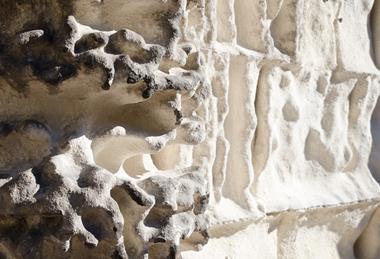 A photograph showing acid range damage and chemical weathering to the limestone walls of a church in Italy