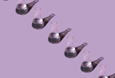 A photographic illustration with glass beakers in a line, each containing a liquid, on a pink background