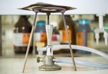 A photograph of a Bunsen burner, tripod and gauze in a laboratory