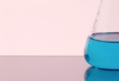 A photograph of a conical flask containing blue copper(II) sulfate solution