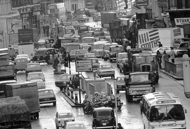 A black and white photo of a traffic jam in London in the 1970s