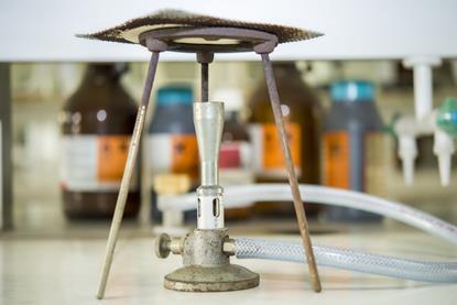 A photograph of a Bunsen burner, tripod and gauze in a laboratory