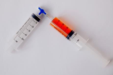 Two syringes connected via a valve. One is empty and the other has 40 millilitres of an orange gas