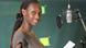 Former DW trainee Liz Shoo in front of a microphone during a recording in the radio studio.