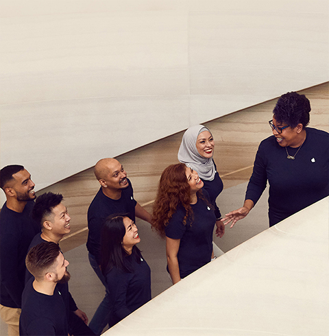 Tiimiläisiä nousemassa ylös portaita Apple Storessa.