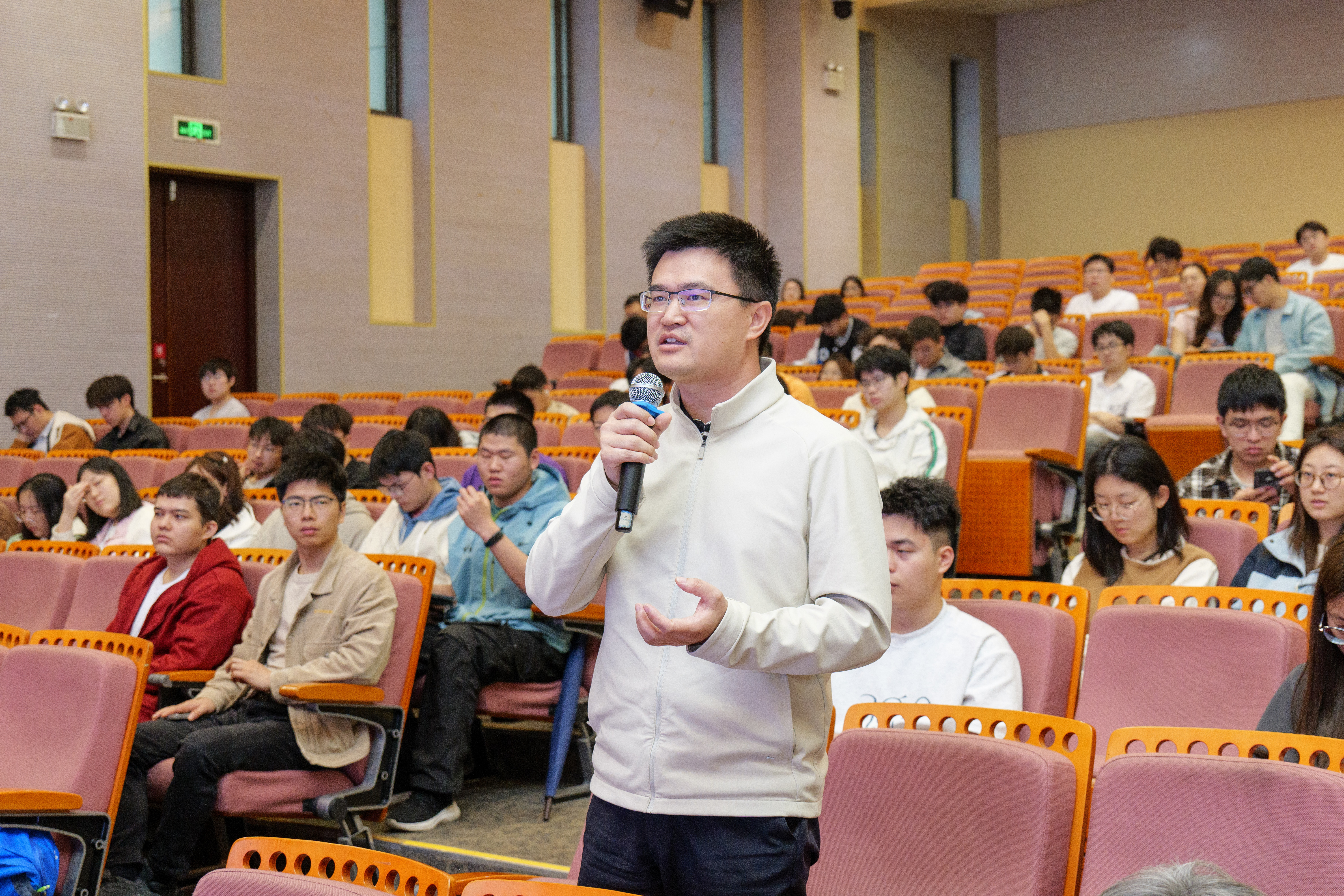 a man holding a microphone in front of a group of people
