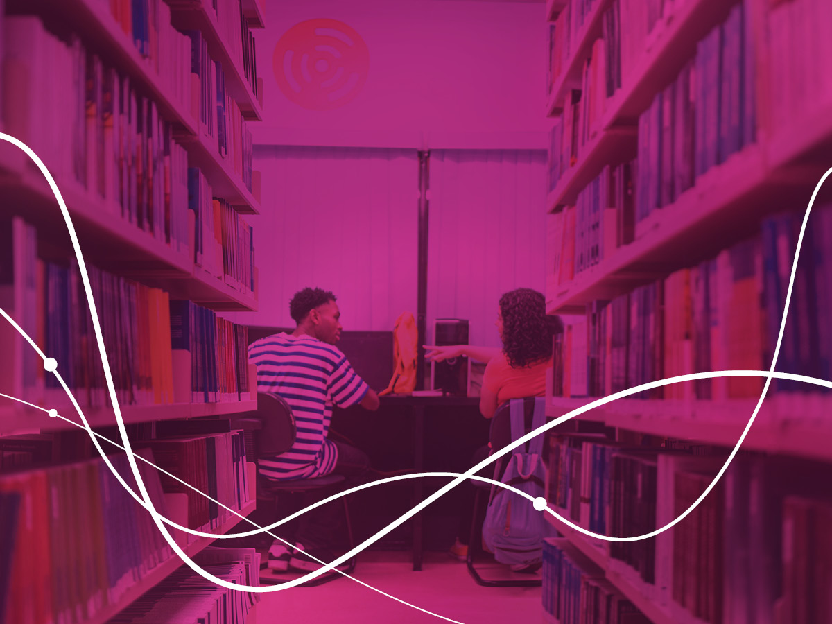 a man and woman sitting at a desk in a library
