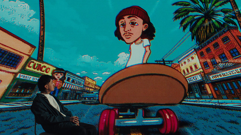 Musician Cuco looks up at an animated version of himself skateboarding down a street in LA.