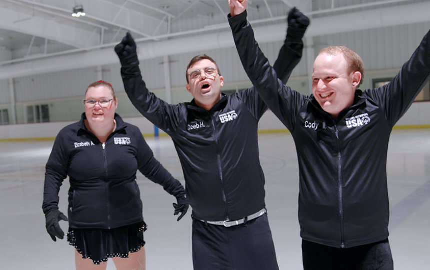 Elizabeth, Deeb, and Cody, Special Olympics figure skaters, celebrating at the rink.