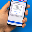 A man&#x27;s hand holds a new iPhone with a prompt to allow or not allow Facebook to track activity on the screen.