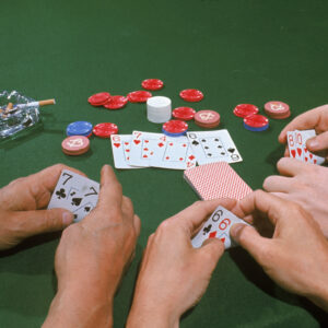 View of three hands in a game of Texas Hold 'Em, one with a pair of sevens, one a pair of sixes, and the other an eight and ten, August 1968.