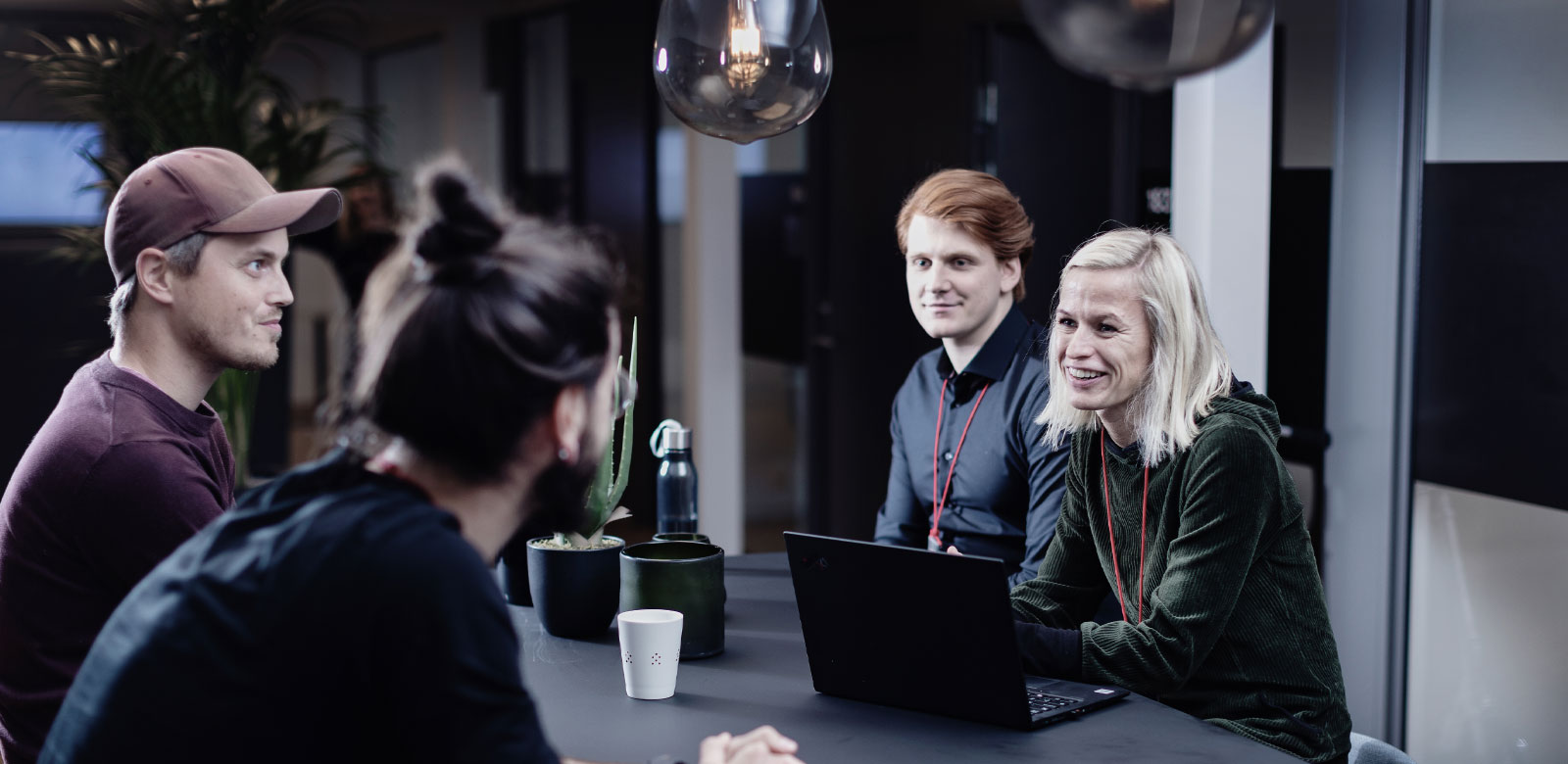 The image showcases a group of people in an indoor setting. They appear to be engaged in a conversation or meeting.