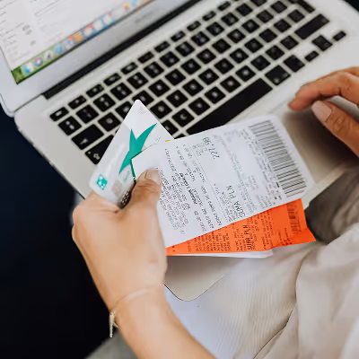 Woman reviewing receipts in front of a laptop
