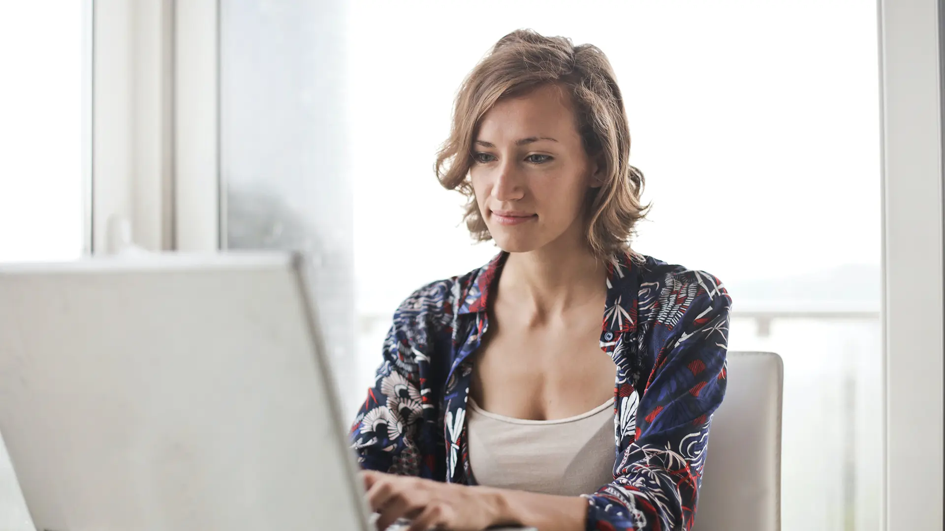 Woman inquisitively looking at laptop