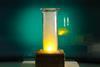 A glass jar with a bright yellow flame and white smoke
