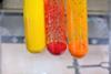 Test tubes containing yellow, red and orange substances formed by the combination of two solutions