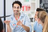 A male teacher animatedly talks to his younger teenager students about a molecule