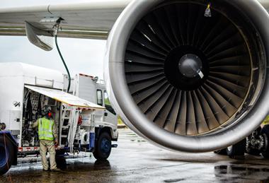 Van with person in hi-vis refueling a jet engine