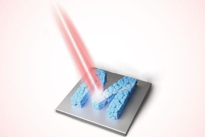 A laser targets an M made of squished blue blobs on a metallic sheet