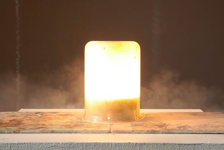A small flash of heat, light and smoke contained within a large glass beaker