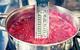 Boiling jam and thermometer in a saucepan.