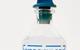 A close-up image of a glass bottle of dilute hydrochloric acid with a blue stopper