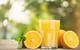 photo of a glass of orange juice on an outdoor table with orange decorations