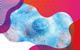 photo of a blue bath bomb surrounded by blue and pink bubbles