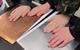 A silver coloured metal sheet and bronze coloured metal sheet with hands placed on them to perform the experiment