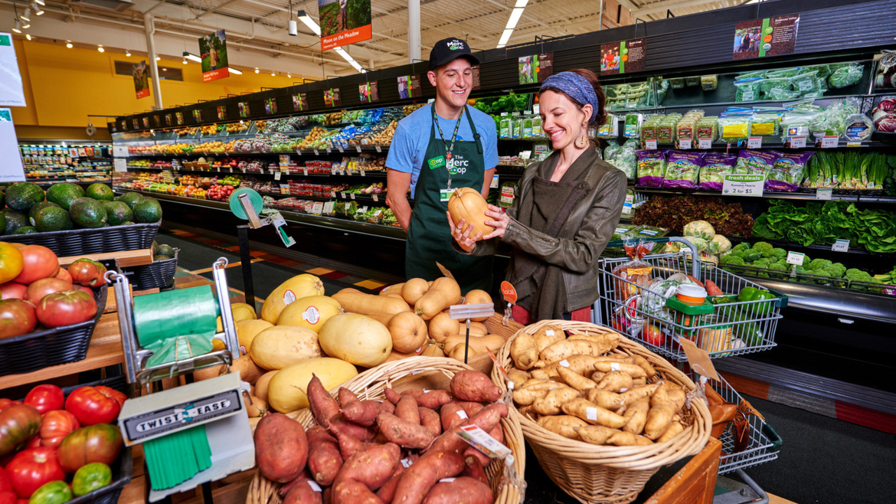 A worker at NCG helps a customer with squash. A worker at NCG helps a customer with squash.