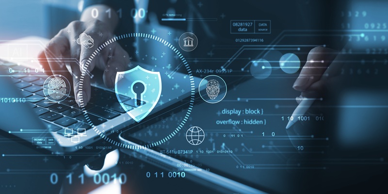 Shield icon with digital symbols, overlaid over a laptop and tablet with stylus