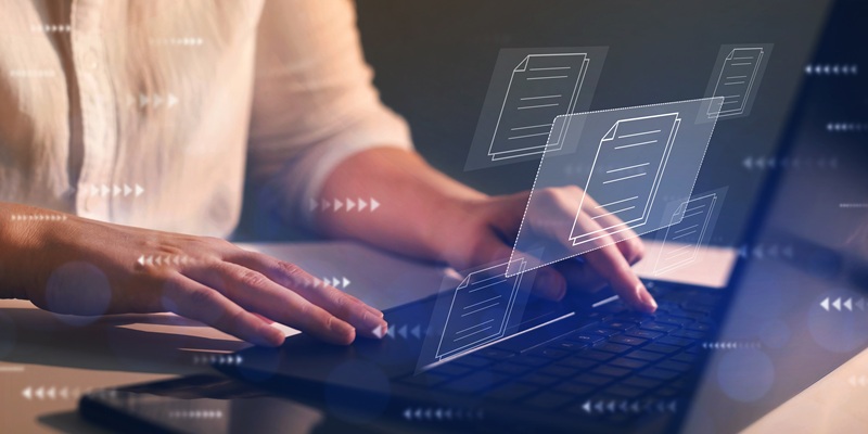Hands typing on a laptop with stylized images of documents floating above