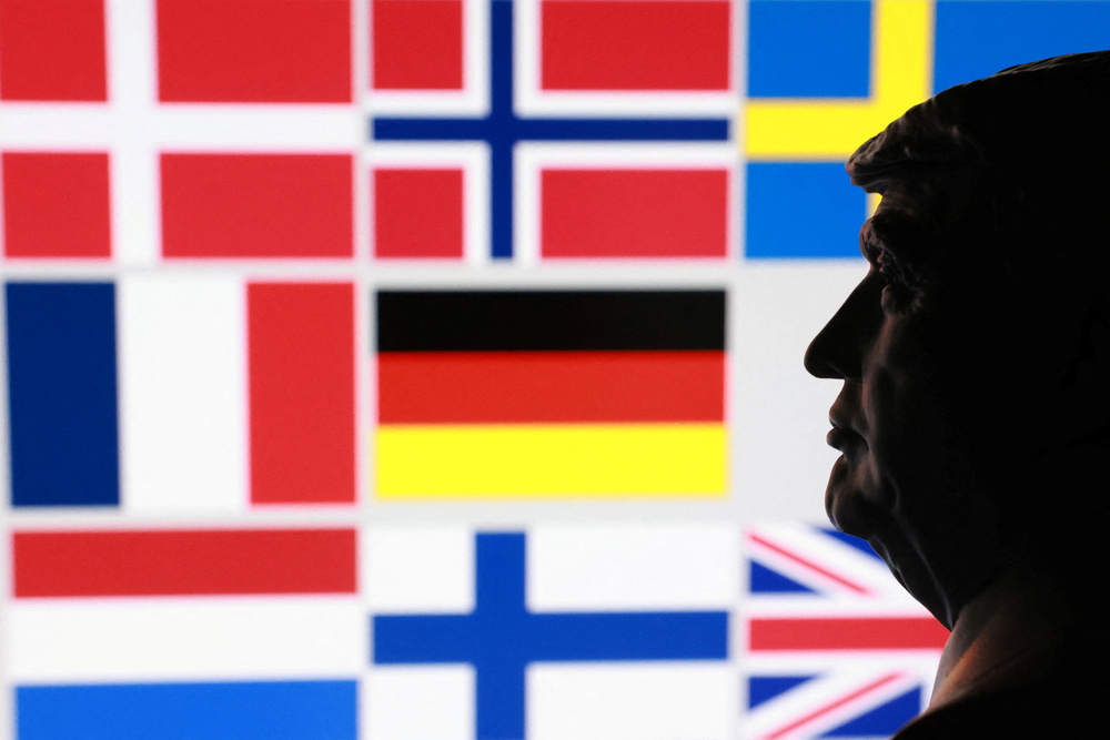 トランプ米大統領のミニチュア像と、グリーンランドを巡り関税を課すとした対象8カ国の国旗(ロイター=共同)