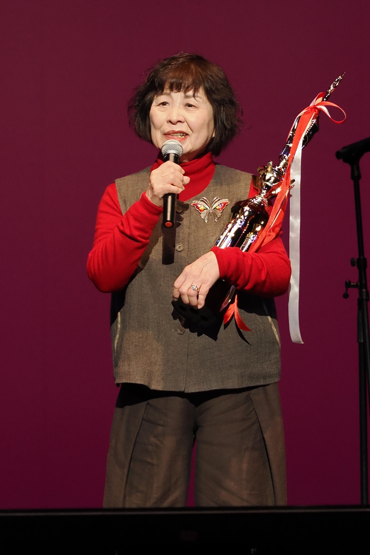 最優秀シルバー歌謡大賞に輝き、トロフィーを手に熱唱する第1部の太田さん=22日、奈良市三条宮前町のなら100年会館大ホール