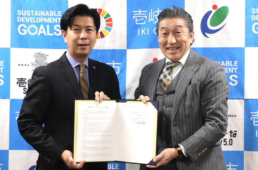 壱岐市と協定を締結した国際志学園の水嶋理事長(右)=同市役所