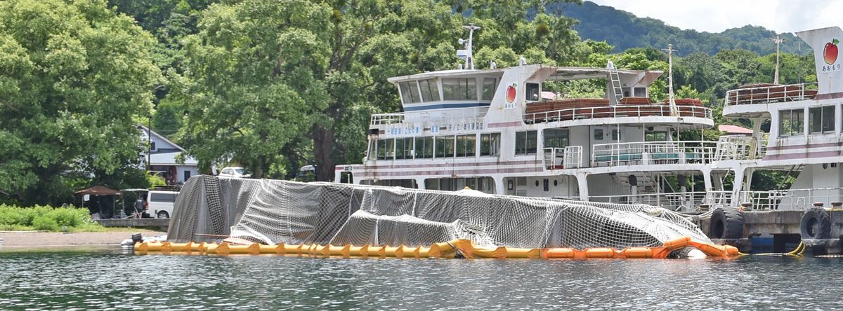 十和田湖畔宇樽部地区に放置されている遊覧船。手前は雪の重みで横転した第3十和田丸＝7月18日