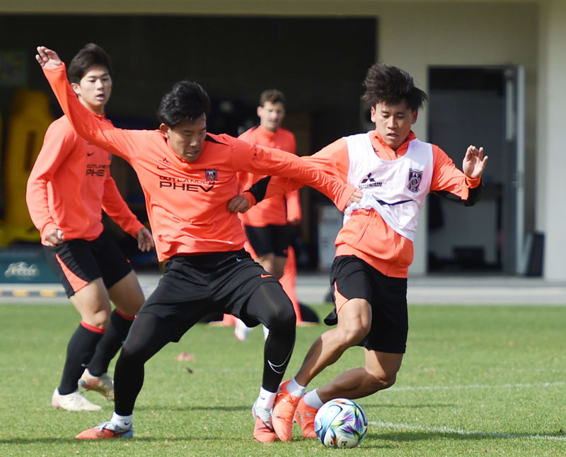 安居(右)と松永がボールを奪い合う=22日午前、沖縄県の金武町フットボールセンター