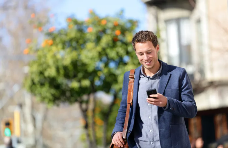 How to get found online - Man looks at phone while walking.