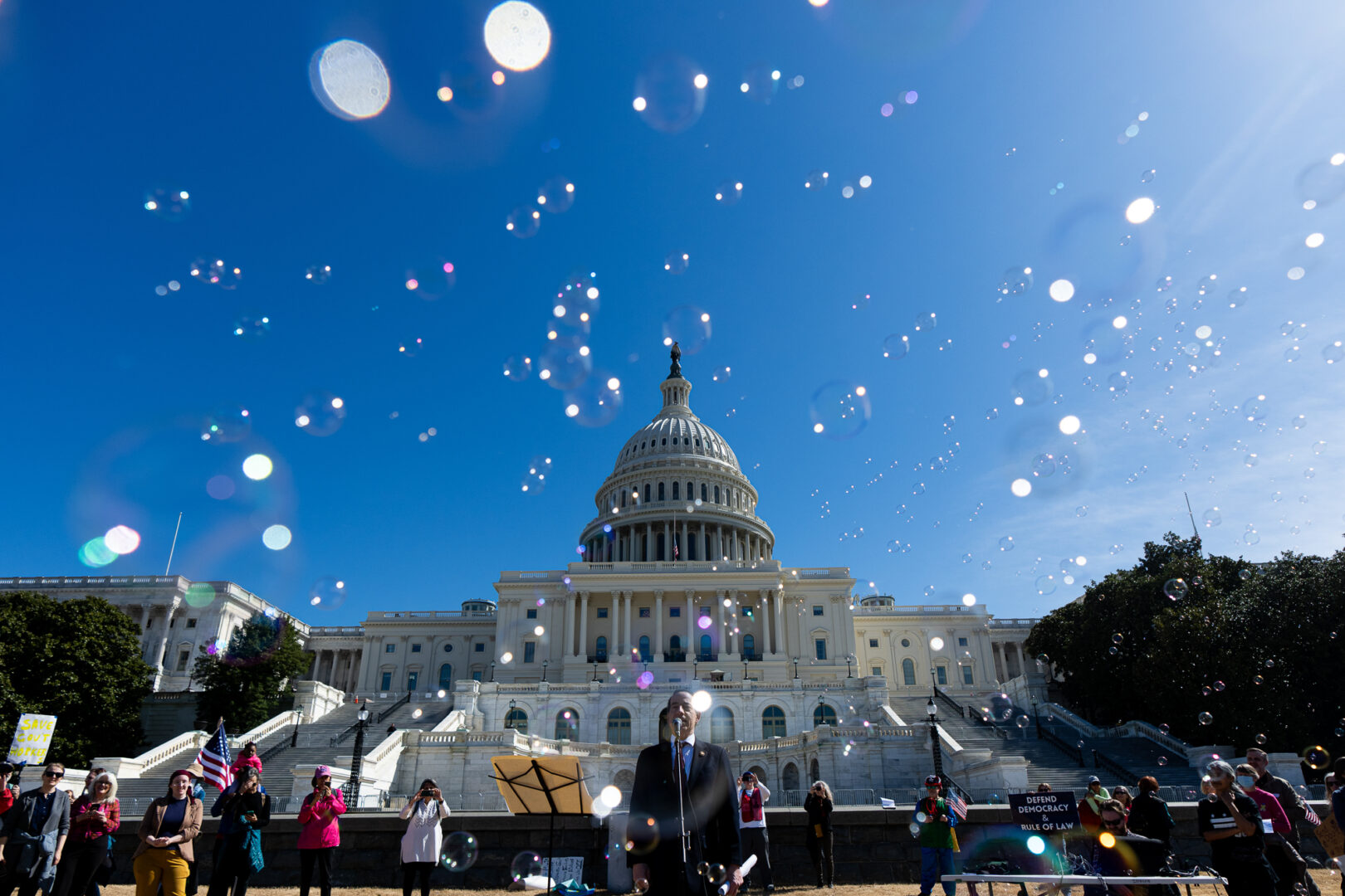 Bubbles fly by as Rep. Jamie Raskin, D-Md., speaks at a rally on the West Front of the Capitol on Monday. Several activists used bubble guns to blow bubbles over the rally. (Bill Clark/CQ Roll Call)