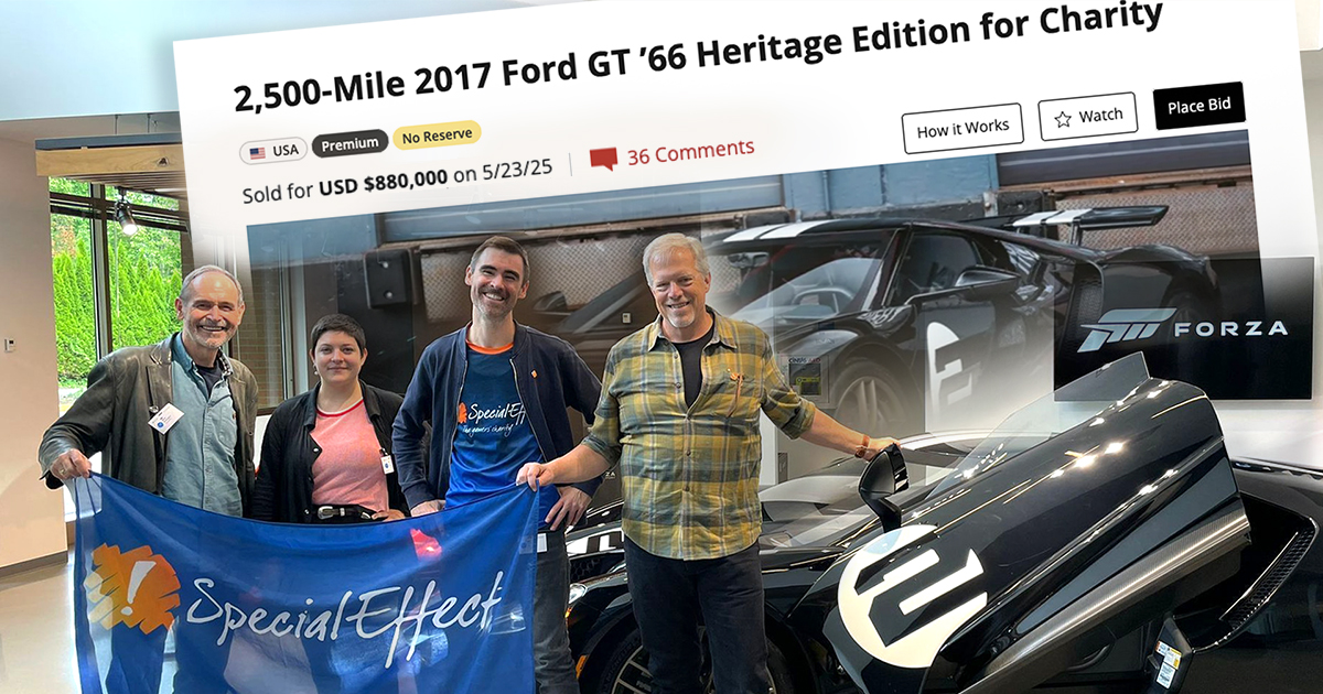 A group of four people holding a blue SpecialEffect flag, standing next to a Ford GT with a number 2 painted in white on the door. The background contains a screenshot of the auction page.
