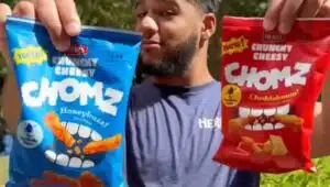 A Herr's team member holding two bags of Herr's new Crunchy Cheesy Chomz.
