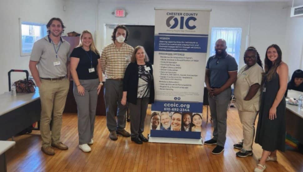 Chester County OIC staff and partners standing together beside a CCOIC banner during an October 2025 community event promoting education and workforce programs.