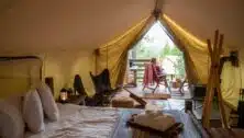 woman sitting outside luxury camping tent.