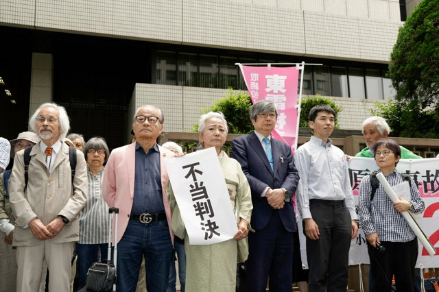 不当判決の紙を掲げる原告団の木村結代表=2025年6月6日午前11時36分、東京都千代田区の東京高裁前、小林正明撮影