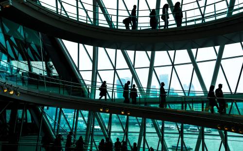 People walking on a circular staircase inside a modern building, showcasing architectural design and movement